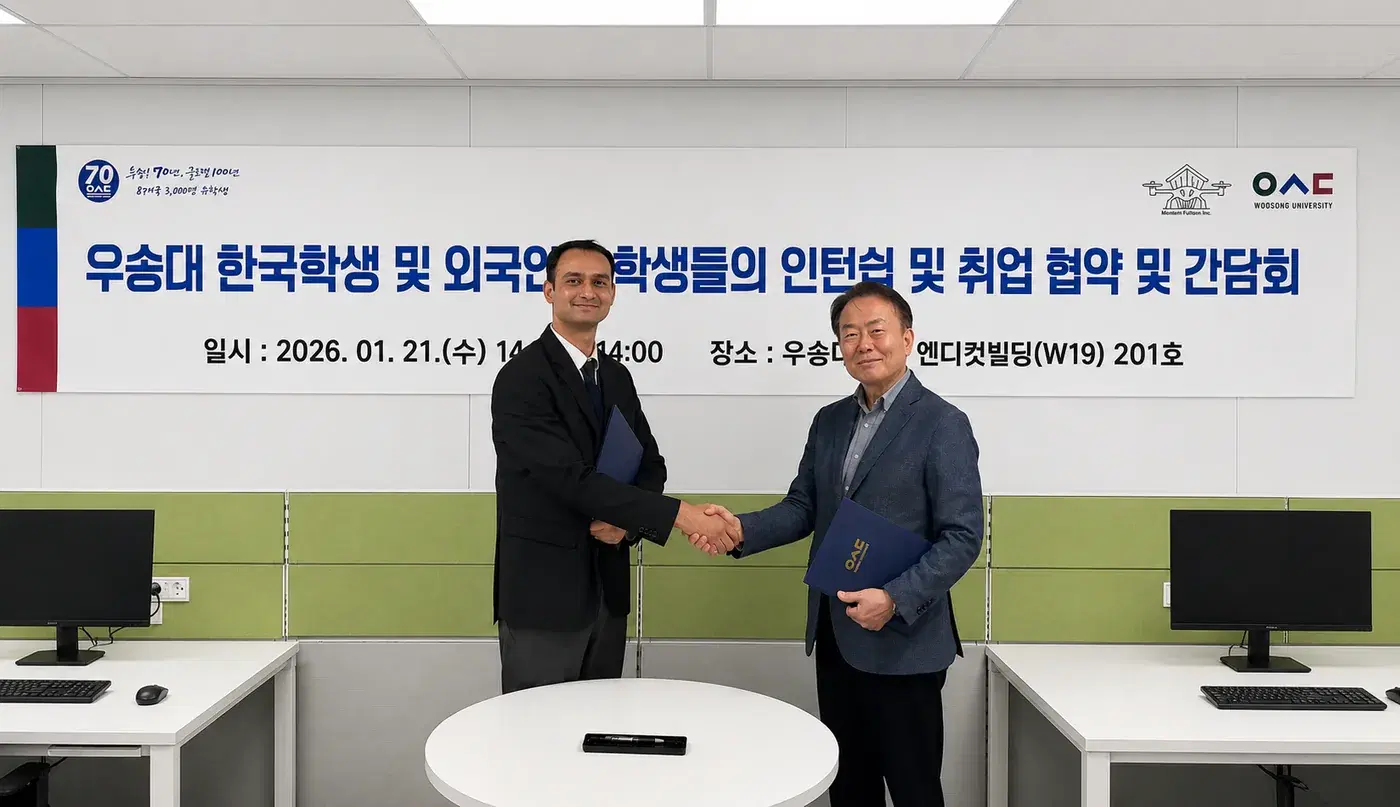 Montemflumen and a Woosong University representative shaking hands in front of the agreement banner after the signing.